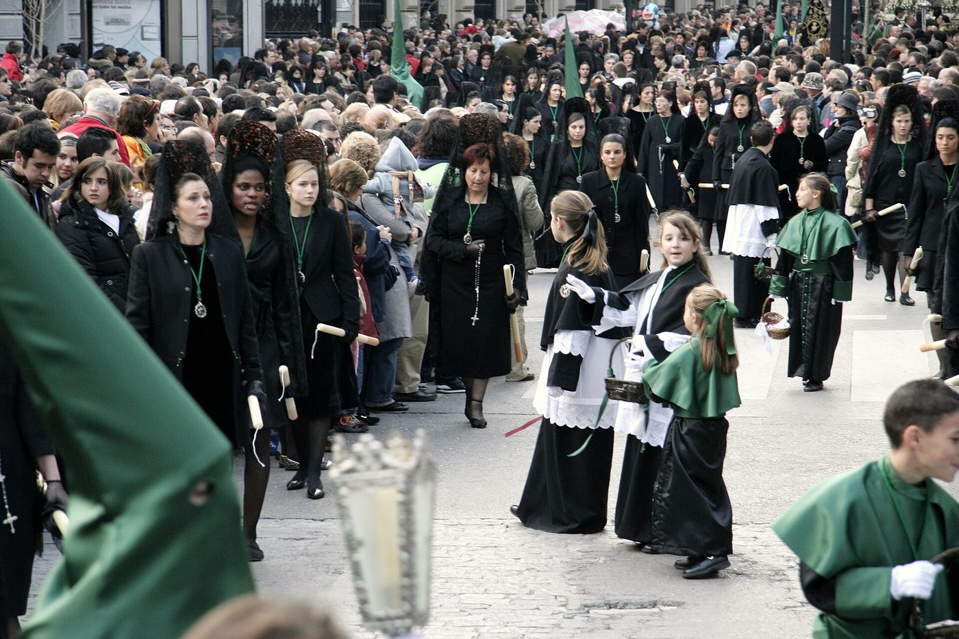 Nazarenos y público en una procesión de Semana Santa en Granada